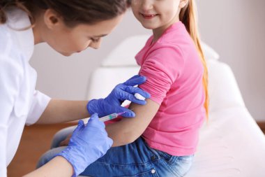 Küçük kız klinikte suçiçeği aşısı oluyor, yakın plan. Varicella virüs önleme
