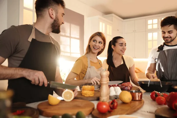 幸せな人々が台所で一緒に料理を作る — ストック写真