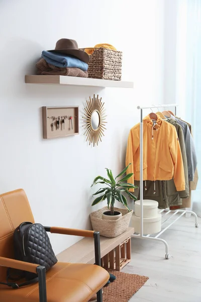 Hallway interior with stylish furniture, clothes and accessories