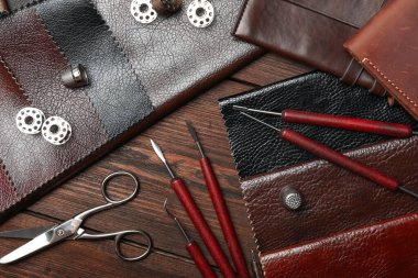 Düz kompozisyon, deri örnekleri ve ahşap masa üzerinde aletler.