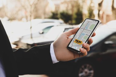 İş adamı şehir caddesinde akıllı telefonlu bir taksi istiyor.