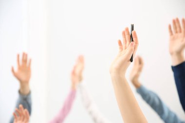 İş eğitiminde beyaz arka plan üzerine sorular sormak için el kaldıran insanlar, yakın plan