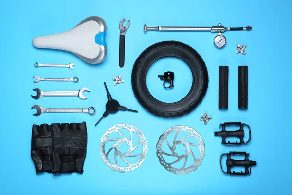 浅蓝色底平铺的一套不同的自行车工具和零件 — 图库照片