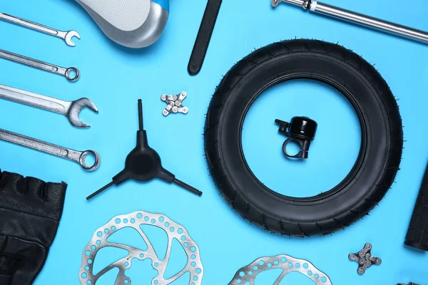 浅蓝色底平铺的一套不同的自行车工具和零件 — 图库照片