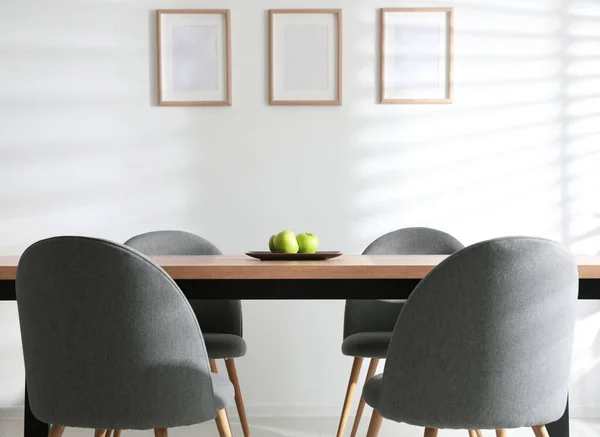 Plate with apples on wooden table indoors. Stylish interior design