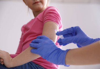 Küçük kız klinikte suçiçeği aşısı oluyor, yakın plan. Varicella virüs önleme