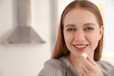Bulanık arka planda vitamin hapı olan genç bir kadın. Metin için boşluk