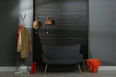 Koridorun içinde kanepe, giysi ve aksesuarlar var.