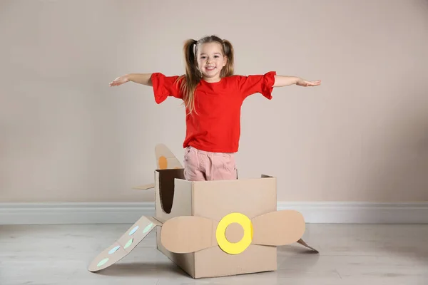 Niedliches Kleines Kind Spielt Mit Pappflugzeug Nahe Beiger Wand — Stockfoto