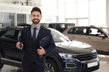 Araba galerisinde anahtarı ve panosu olan bir satıcı.