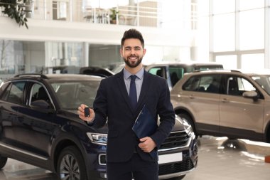 Araba galerisinde anahtarı ve panosu olan bir satıcı.