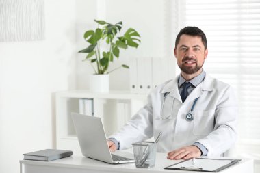 İş yerinde beyaz önlüklü erkek doktorun portresi.