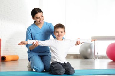 Hastanenin spor salonunda küçük bir çocukla çalışan ortopedist.