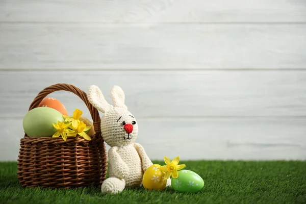 五彩缤纷的复活节彩蛋 野兔和水仙花缀在绿草上 衬托着白色的背景 案文的篇幅 — 图库照片