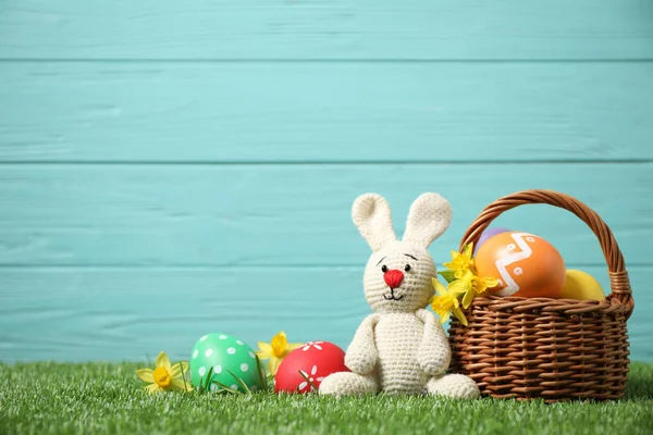 五彩缤纷的复活节彩蛋 篮子和兔子玩具 绿色草地上 背景为浅蓝色 — 图库照片