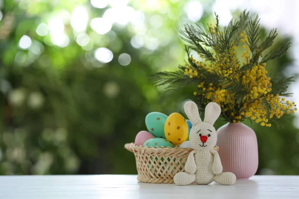 复活节兔子玩具 色彩斑斓的蛋和花在白色木制桌子上 绿色背景模糊 案文的篇幅 — 图库照片