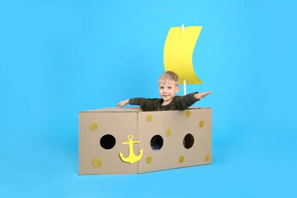 Niño Jugando Con Barco Hecho Caja Cartón Sobre Fondo Azul — Foto de Stock