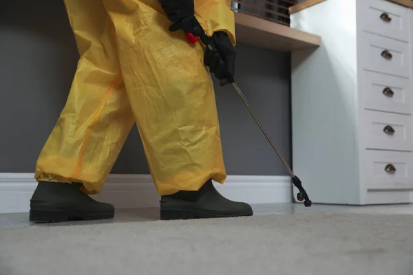 自宅で床に殺虫剤を噴霧保護スーツの害虫駆除の労働者 クローズアップ — ストック写真