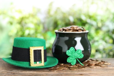 Yeşil leprikon şapka ve altın paralarla ahşap masa. Aziz Patrick Günü kutlaması