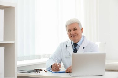 İş yerinde beyaz önlüklü kıdemli doktorun portresi.