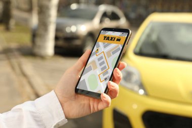 Şehir caddesinde akıllı telefondan taksi çağıran kadın, yakın plan.
