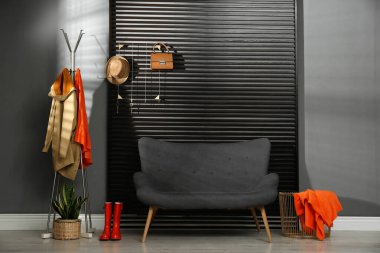 Koridorun içinde kanepe, giysi ve aksesuarlar var.