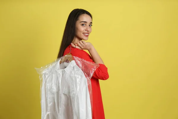 Young Woman Holding Hanger Shirt Plastic Bag Yellow Background Dry — Stok fotoğraf