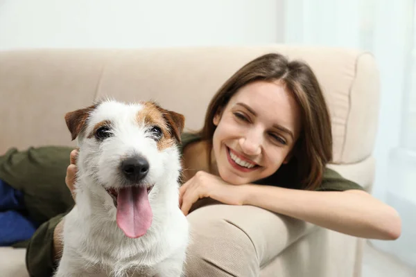 自宅でソファの上に彼女のかわいいジャック ラッセル テリアと若い女性 可愛いペット — ストック写真