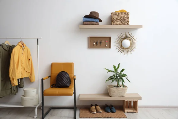 Hallway interior with stylish furniture, clothes and accessories