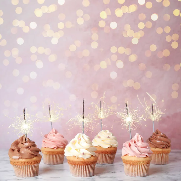 Cupcakes Cumpleaños Con Bengalas Mesa Sobre Fondo Rosa Claro — Foto de Stock