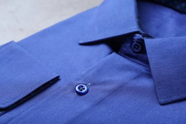 Modaya uygun mavi gömleğin yakın görüntüsü. Kuru temizleme servisi.