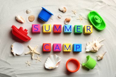 Kum üzerinde renkli küplerden yapılmış SUMER CAMP ifadesi ile düz konum