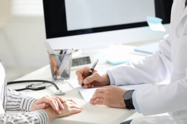 Ofisteki hastayla çalışan doktor, yakın plan.