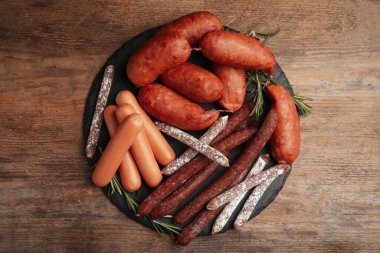 Ahşap masada farklı lezzetli sosisler, üst manzara.