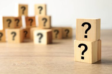 Tahta arka planda soru işaretleri olan küpleri. Metin için boşluk