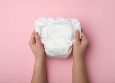 Pembe arka planda bebek bezi olan kadın, yakın plan.