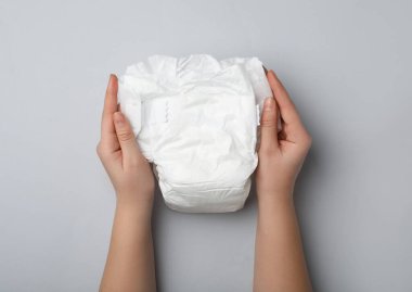 Açık gri arka planda bezi olan kadın, yakın plan.