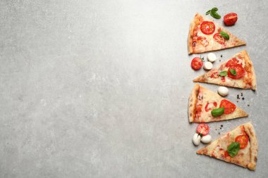 Açık gri masada Margherita pizza dilimleri, düz. Metin için boşluk