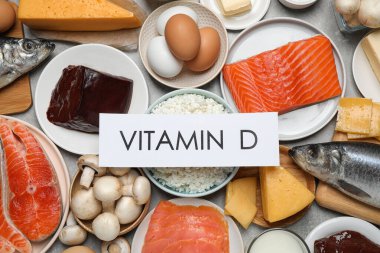 Deyimi VITAMIN D olan kağıt ve masa üzerinde taze ürünler, düz yatıyordu
