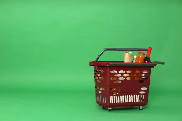 Yeşil Arka Planda Farklı Ürünlerle Dolu Bir Alışveriş Sepeti Metin — Stok fotoğraf