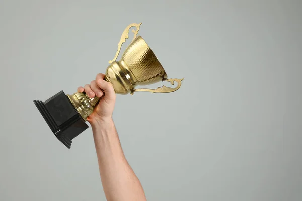 Hombre Sosteniendo Copa Trofeo Oro Sobre Fondo Gris Claro Primer — Foto de Stock