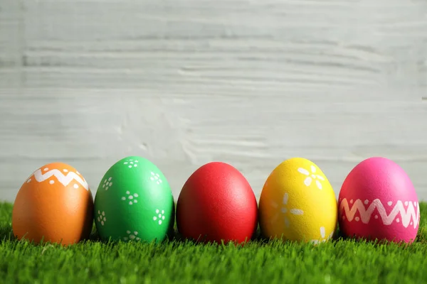Beyaz Arka Planda Yeşil Çimlerde Renkli Paskalya Yumurtaları Metin Için — Stok fotoğraf