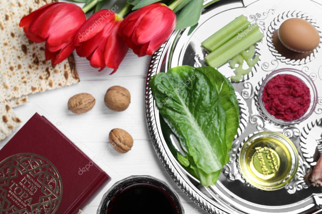 Flat lay composition with Passover Seder plate (keara) on white wooden table. Pesah celebration