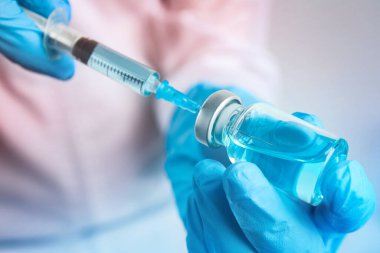 Şırıngayı ilaçla dolduran doktor, yakın çekim. Aşılama ve aşılama