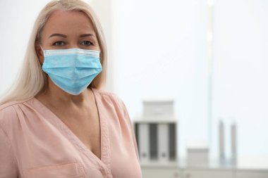 İçeride tıbbi maske takan olgun bir kadın, mesaj için yer var. Tehlikeli bir virüs.