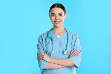 Mavi arka planda steteskobu olan genç doktorun portresi.