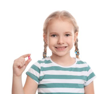 Beyaz arka planda vitamin hapı olan küçük bir kız.