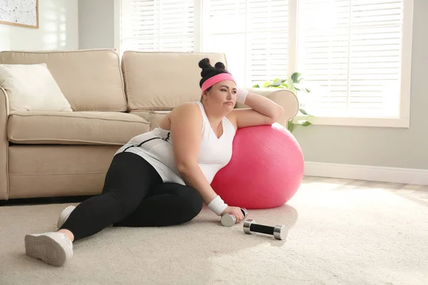 家里地板上有运动器材的懒惰超重妇女 — 图库照片