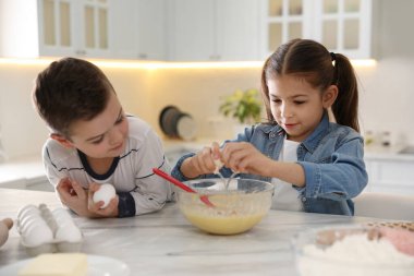 Sevimli küçük çocuklar mutfakta hamur pişiriyorlar.