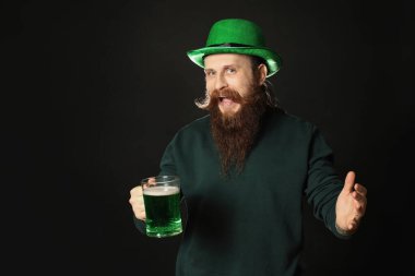 Siyah arka planda yeşil biralı sakallı adam. Aziz Patrick Günü kutlaması